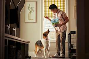 Man holding up a Blue Buffalo treat for his dog
